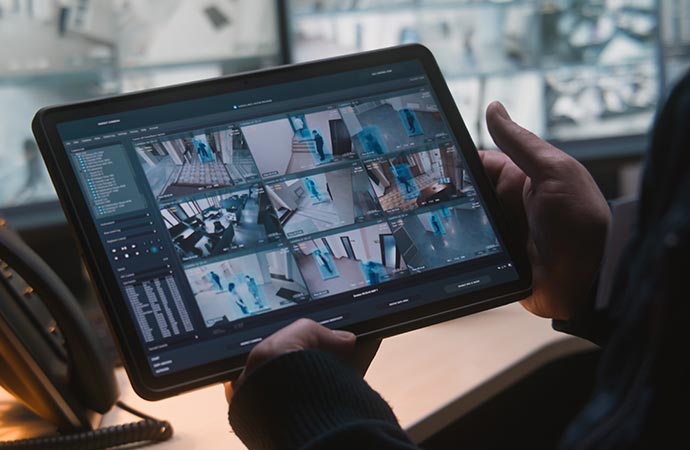 Male security officer controlling CCTV cameras in an office for business automation.