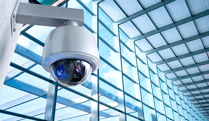 Commercial dome security camera mounted on a wall for surveillance Outdoor dome security camera mounted on a wall, providing surveillance for open indoor spaces