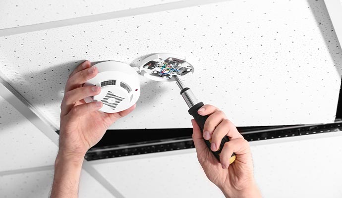 An expert repairing a smoke detector system