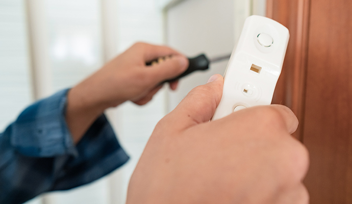 A person installing video doorbell at entrance