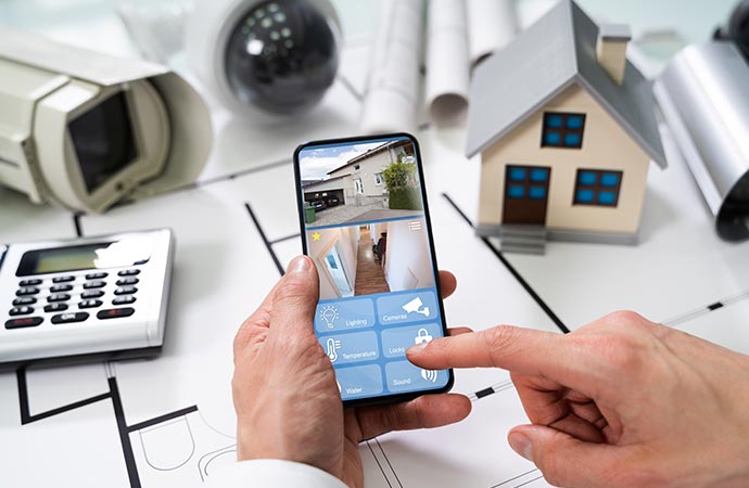 Person using home security system on mobile phone.