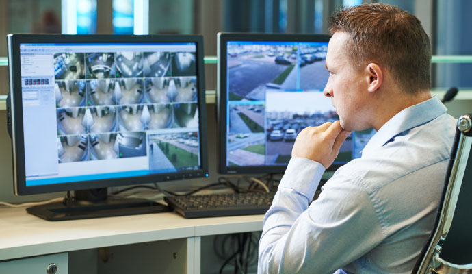 Security monitoring specialist watching surveillance screens