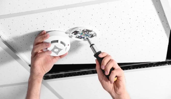 Technician installing fire alarm